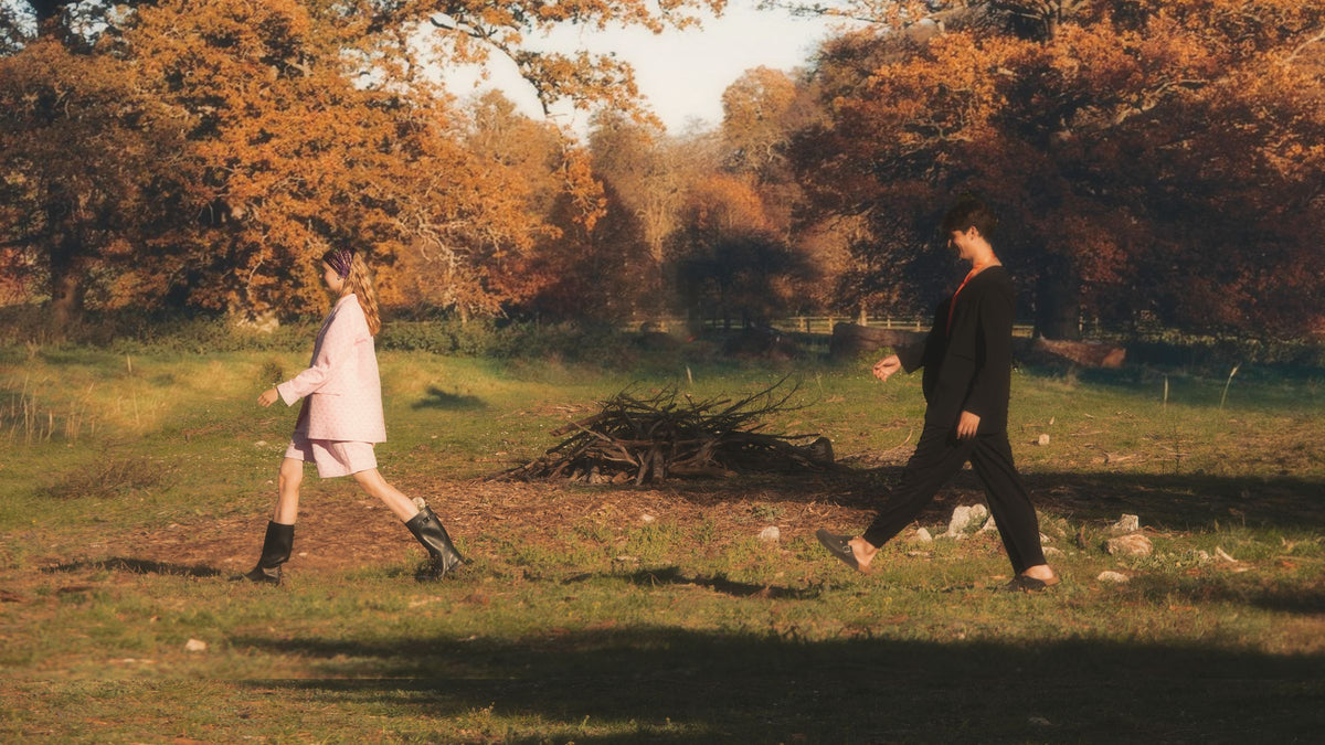 Two models walking through an autumn landscape