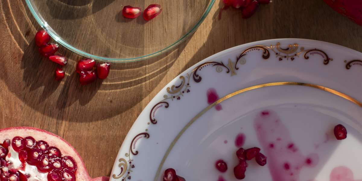 Pomegranate seeds and a petri dish on a wooden table